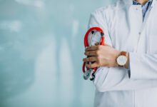 young handsome physician in a medical robe with stethoscope scaled 1